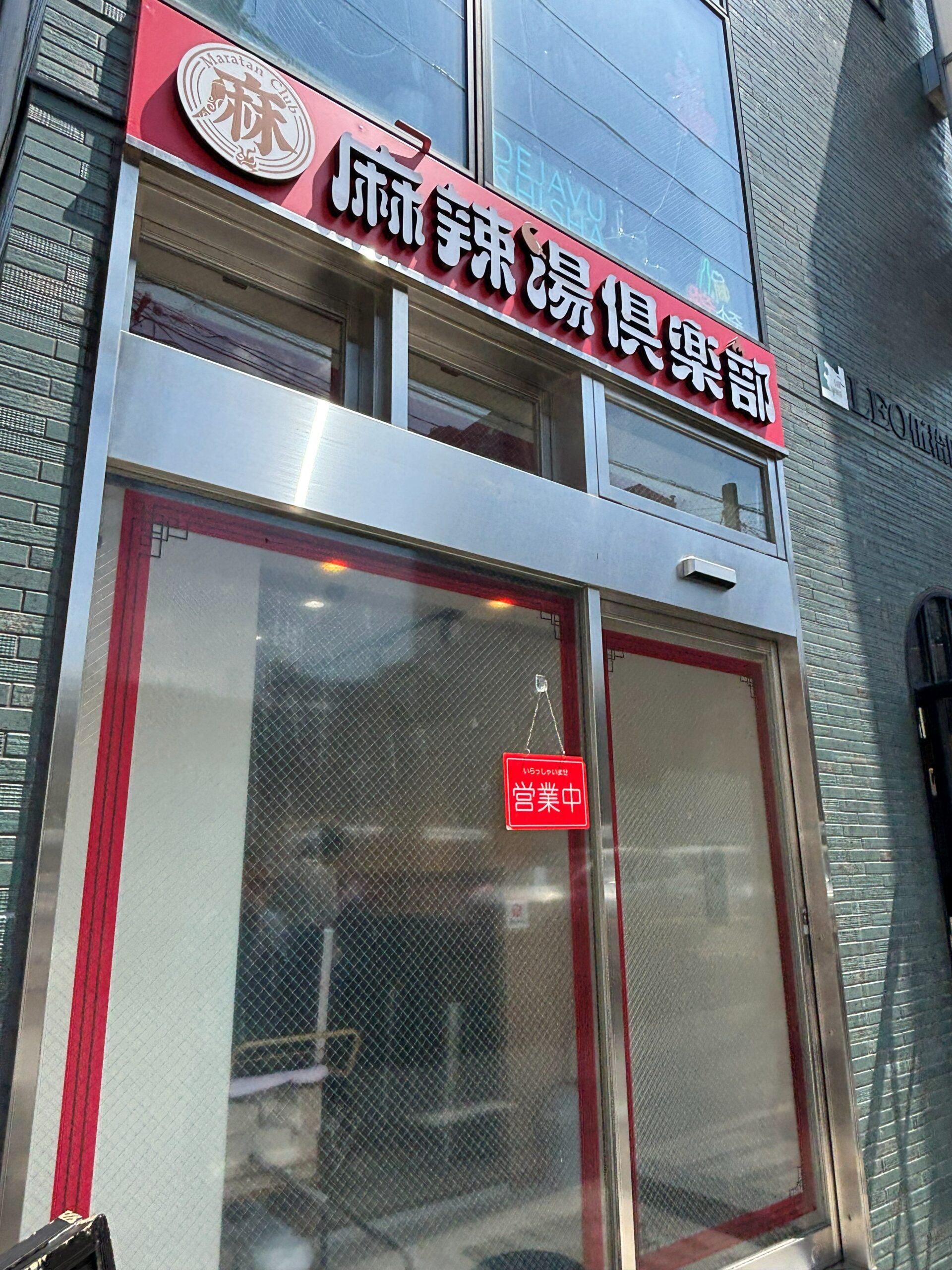 麻辣湯倶楽部 船橋店の外観、赤い看板と営業中の札