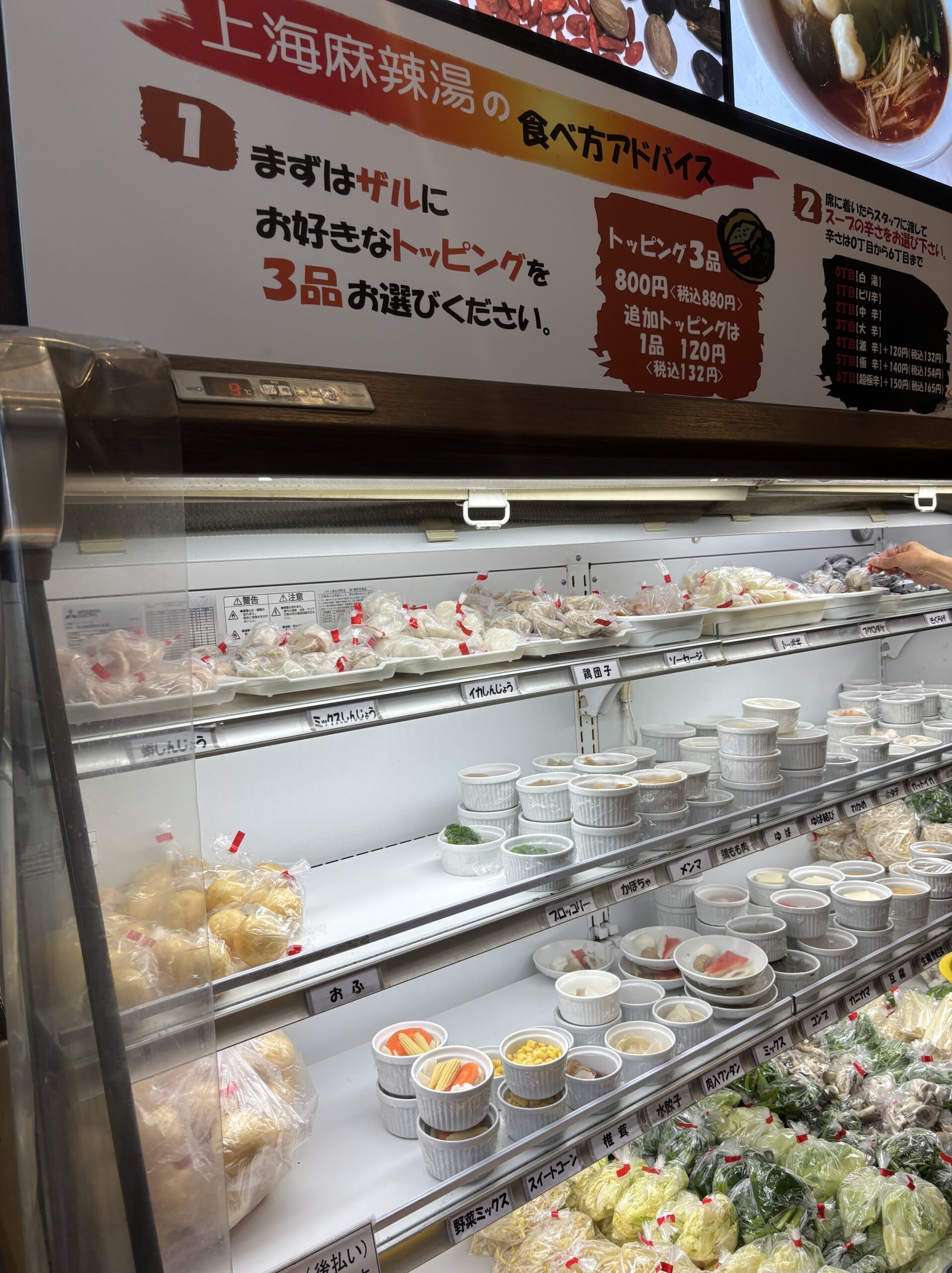 東魁楼 上海麻辣湯のトッピングケースと料金・辛さ表の看板