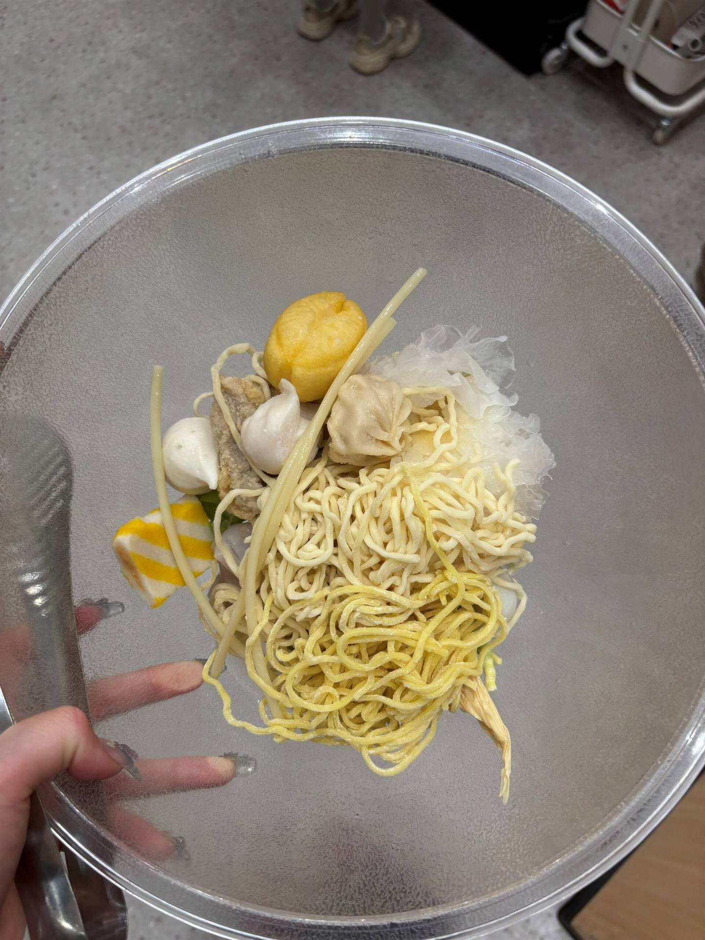 張亮麻辣湯で選んだ麺と具材、黄色い麺や団子、湯葉などを盛ったボウル