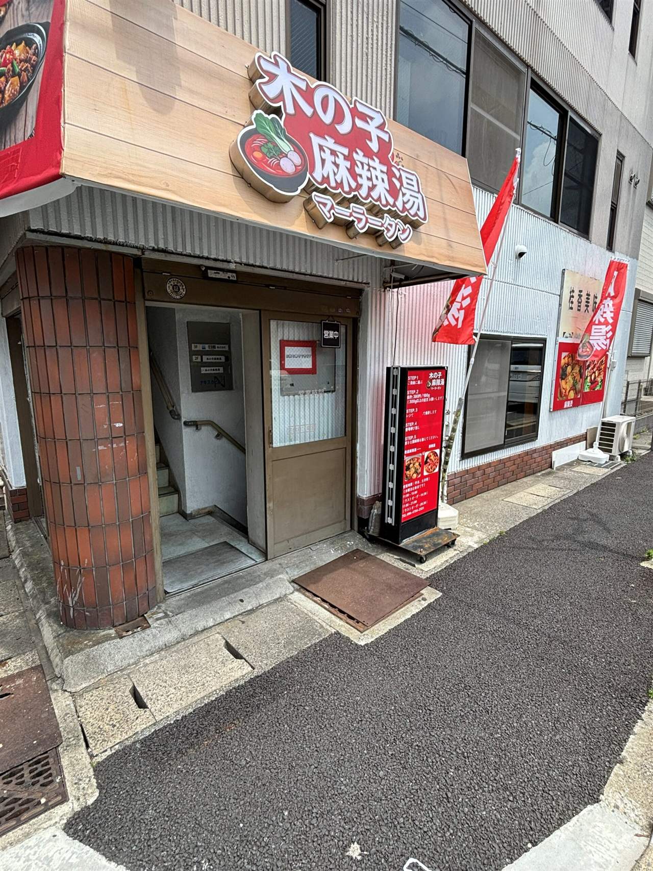 木の子麻辣湯の外観、稲毛海岸のビル2階入口とSTEP案内スタンド