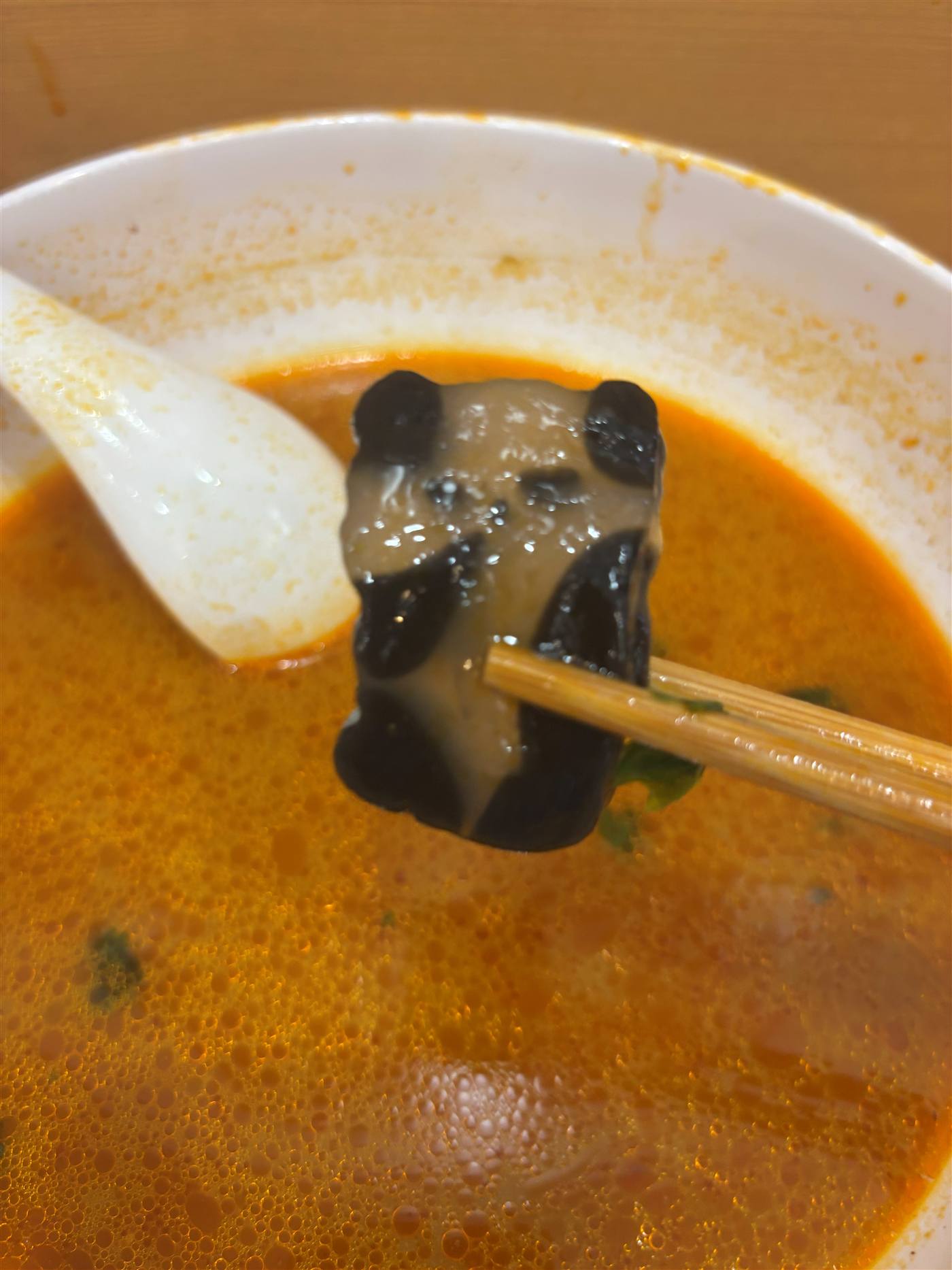 親愛的麻辣湯のパンダの具材を箸で持ち上げているところ