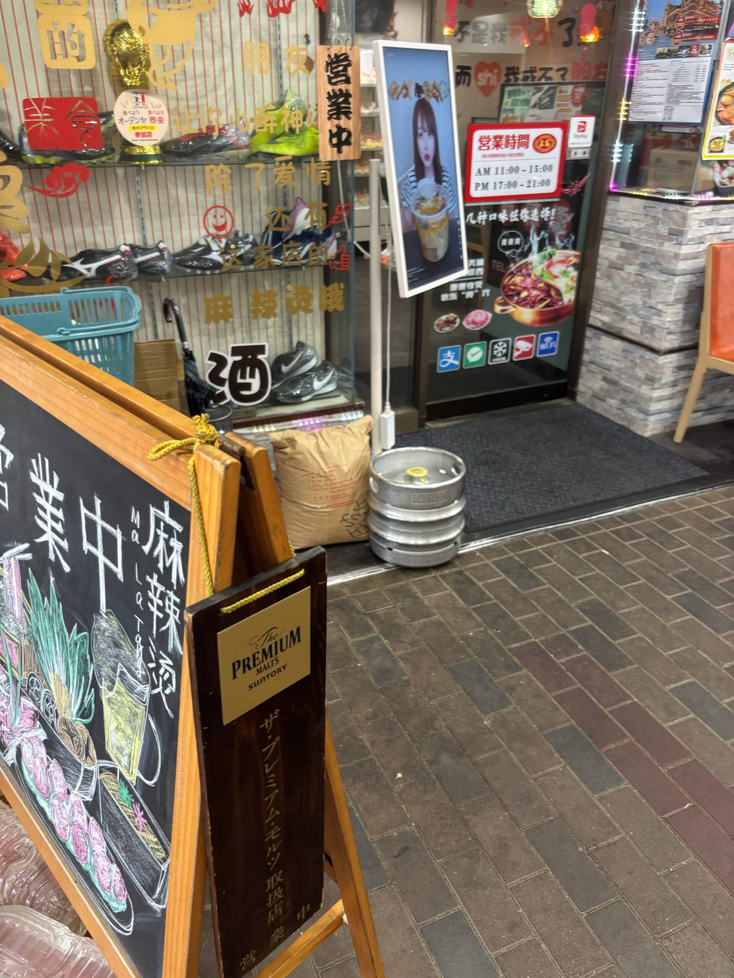 王家 麻辣燙の店頭(営業時間の看板とキャッシュレス対応の案内)