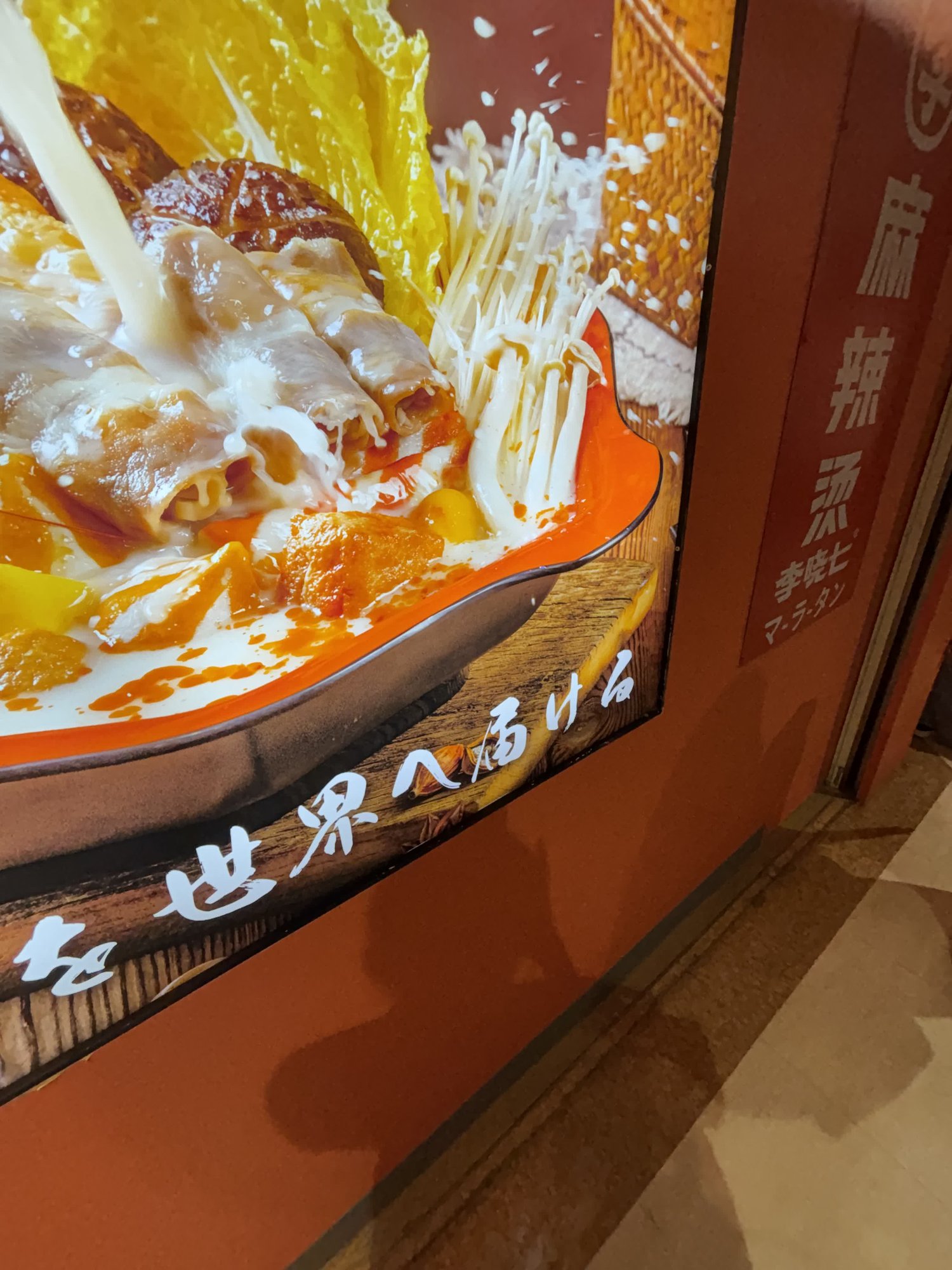 李暁七麻辣湯 田町店の店頭の看板。縦に「麻辣燙」「李暁七」「マーラータン」と書かれている